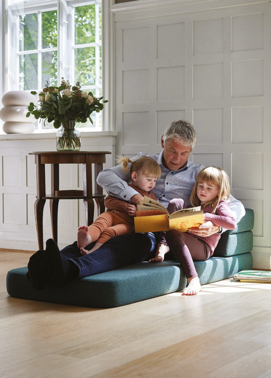 Fauteuil KlipKlap à 3 niveaux vert sapin utilisé comme assise au sol pour lire une histoire à ses petits-enfants
