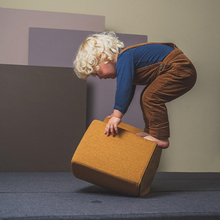 Pouf couleur moutarde en situation avec un enfant qui joue