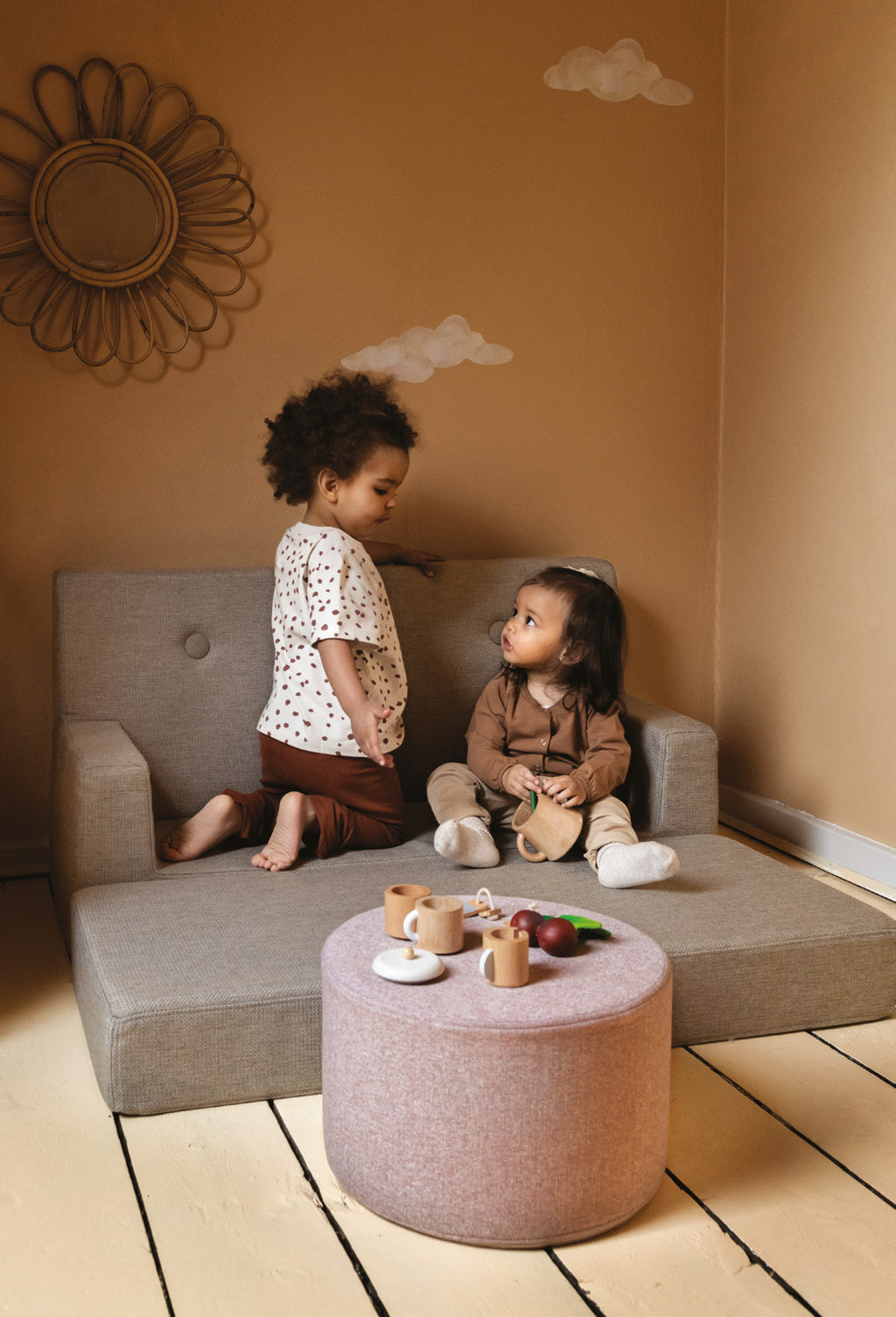Canapé beige et pouf rose de KlipKlap avec des enfants installés