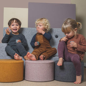 Poufs KK Circle moutarde, rose et gris de KlipKlap avec des enfants assis dessus